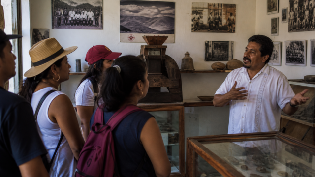 Visitantes observan fotografías y objetos históricos en un museo comunitario mexicano