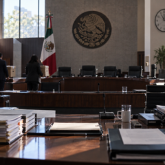 Sala de sesiones del INE durante un relevo administrativo, con expedientes y personal técnico en transición.