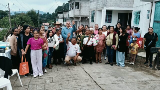 Vecinas y vecinos se reúnen en una calle de Huauchinango para un encuentro comunitario.